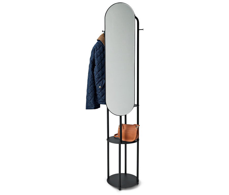 Support noir avec miroir ovale, une veste bleue et un sac à main marron.