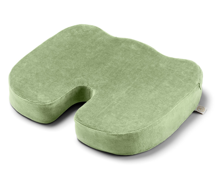 Un coussin d'assise vert avec une découpe au centre.