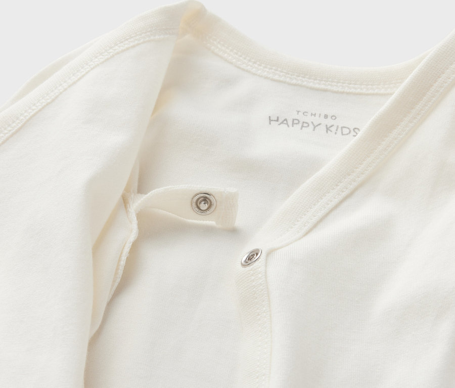 Gros plan sur un des 5 bodys évolutifs pour bébé blancs avec boutons-pression.