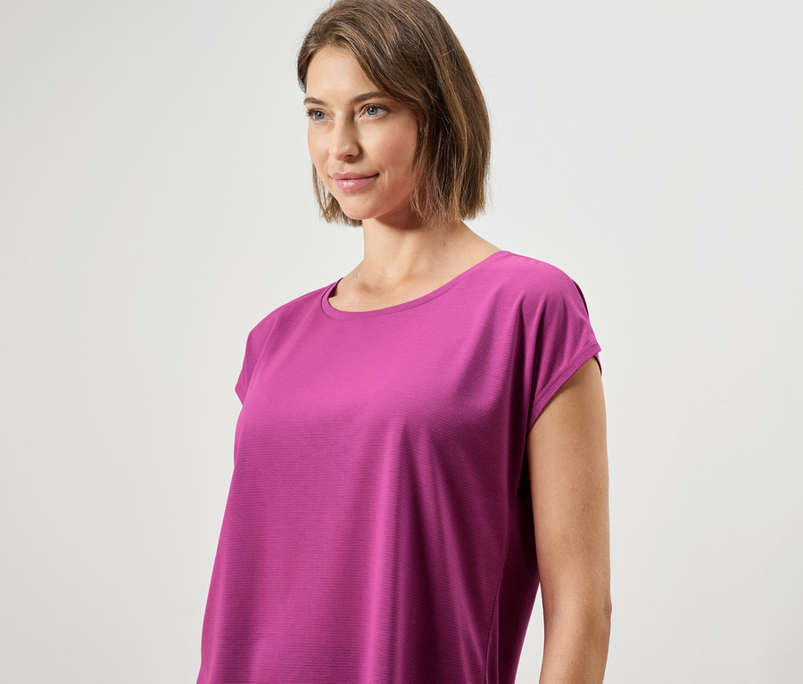 Femme portant un haut rose à manches courtes.