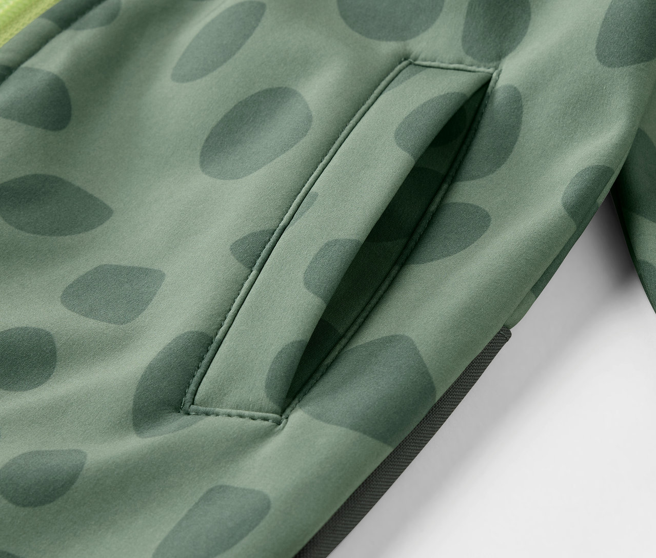 Gros plan sur une combinaison en softshell pour enfant avec un motif et une poche.