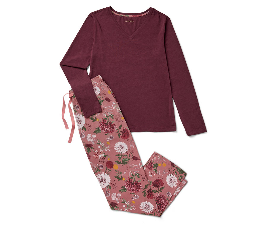 Un pyjama bordeaux à manches longues et un pantalon à fleurs sont posés sur un fond blanc.