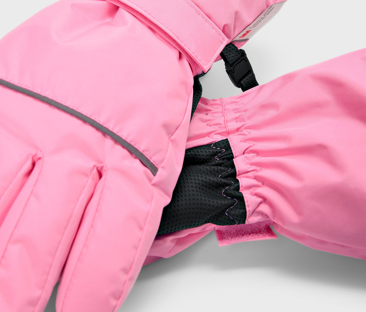 Gros plan de gants de ski roses pour enfants avec poignet intérieur noir.