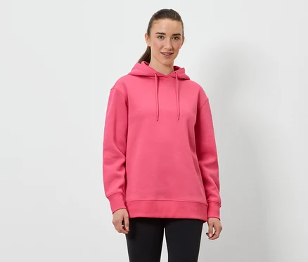 Une femme porte un sweat à capuche rose et un legging noir.