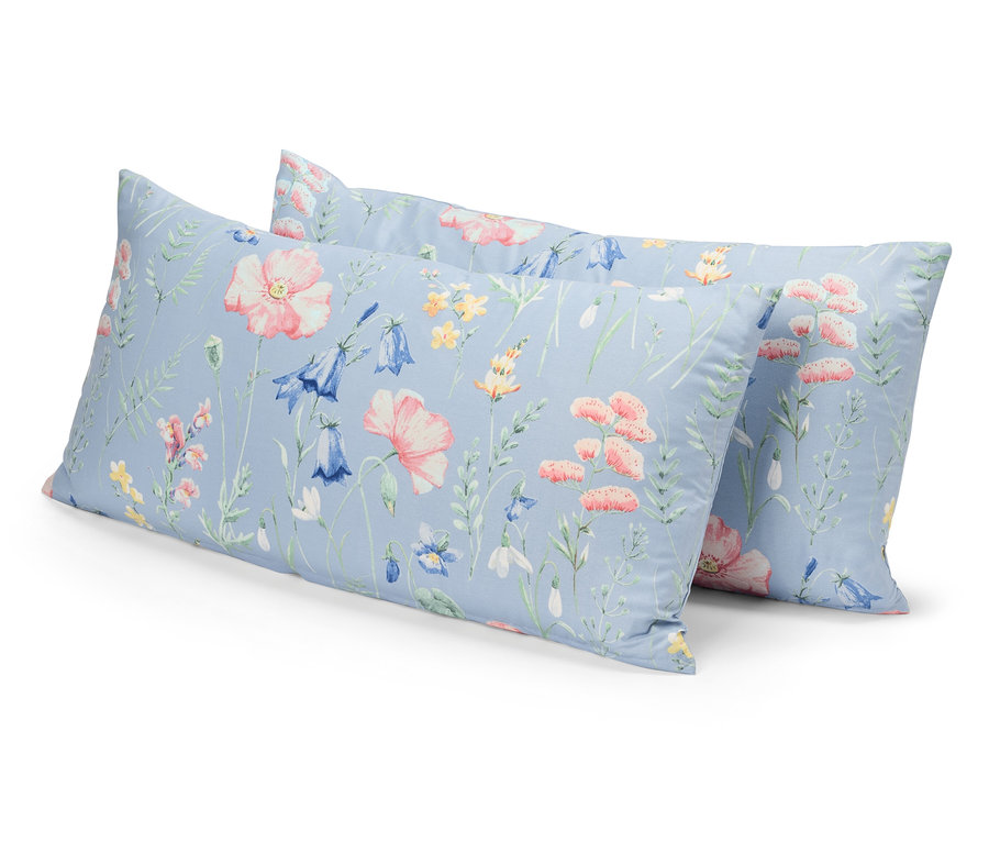 Deux oreillers à motifs floraux sur fond bleu sont placés l'un sur l'autre.