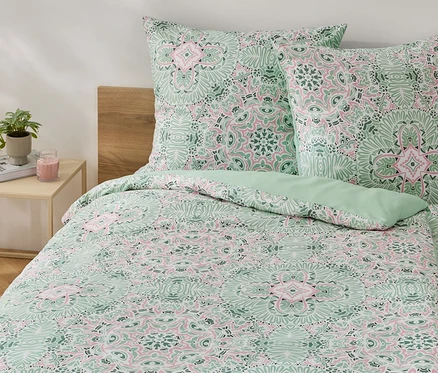 Parure de lit en microfibre verte taille standard avec un motif floral sur un lit.