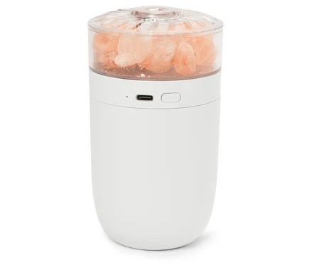 Lampe blanche avec des cristaux de sel roses dans un dessus transparent.