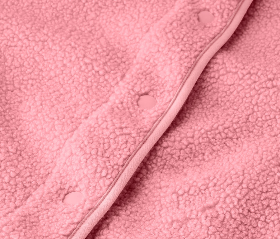 Gros plan sur un gilet sans manches en peluche teddy rose avec des boutons.