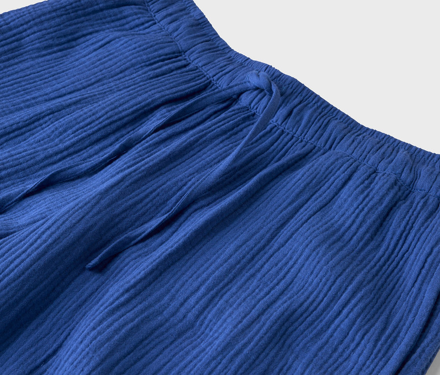 Gros plan d'un pantalon en tissu bleu avec cordon de serrage.