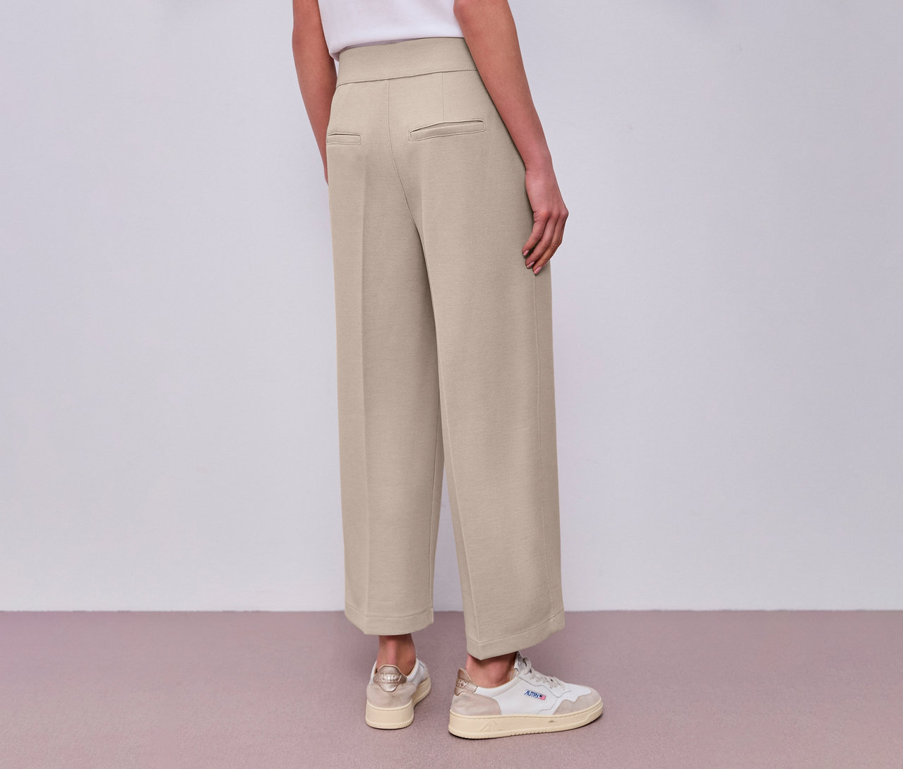 Vue arrière d'une femme portant une culotte 7/8 Street One beige et des baskets blanches.