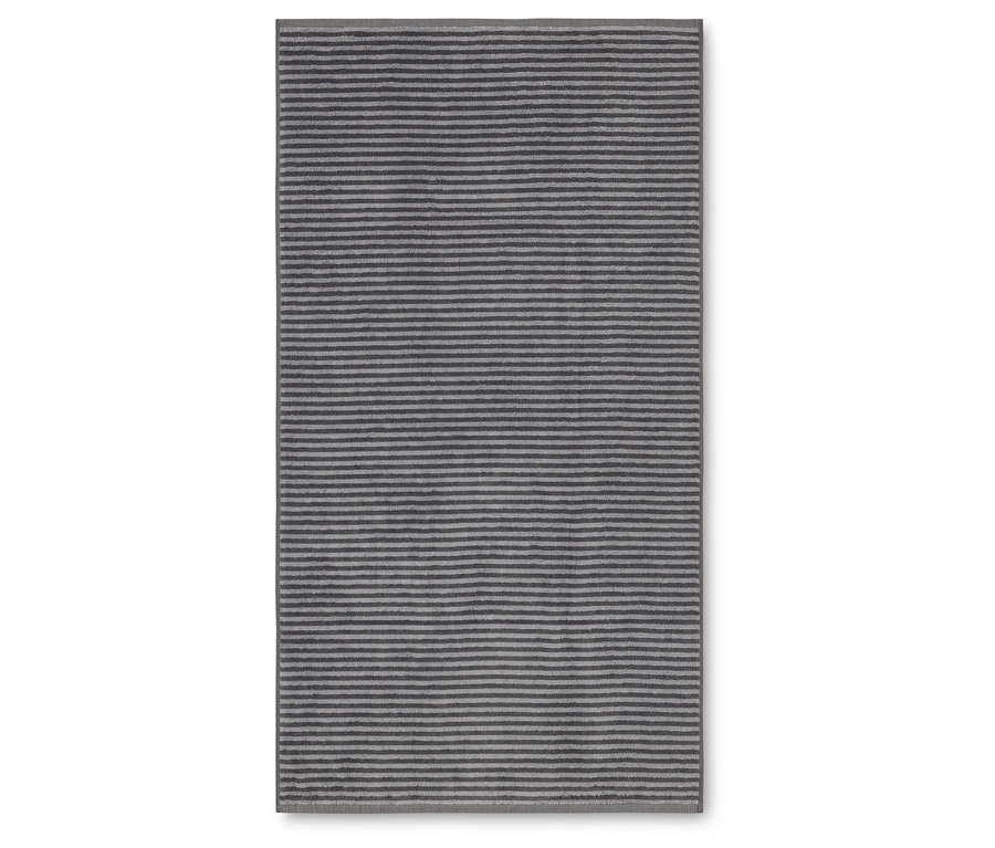 Un tapis rectangulaire à rayures horizontales dans les tons de gris et d'argent repose sur un fond blanc.