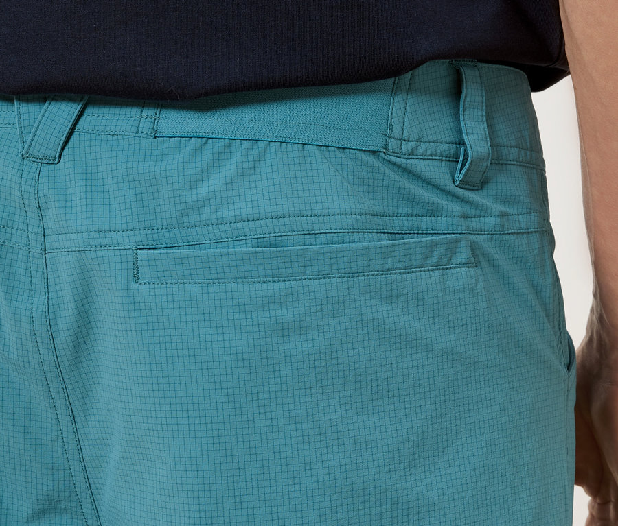 Gros plan sur l'arrière d'un pantalon turquoise avec des poches.