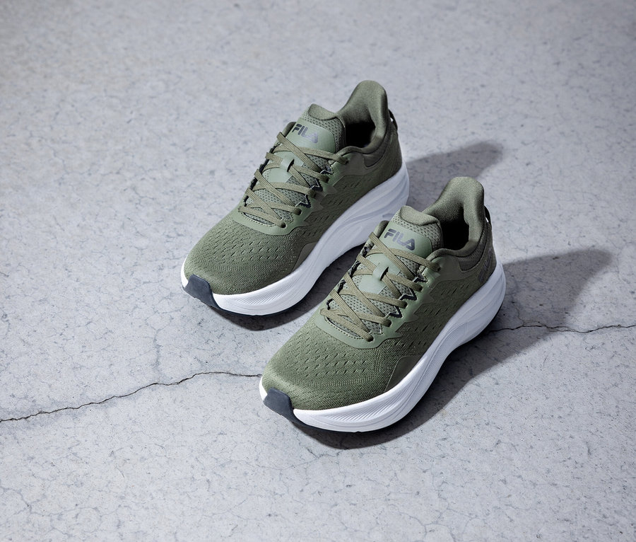 Deux chaussures de course Fila vert olive posées sur un fond gris.