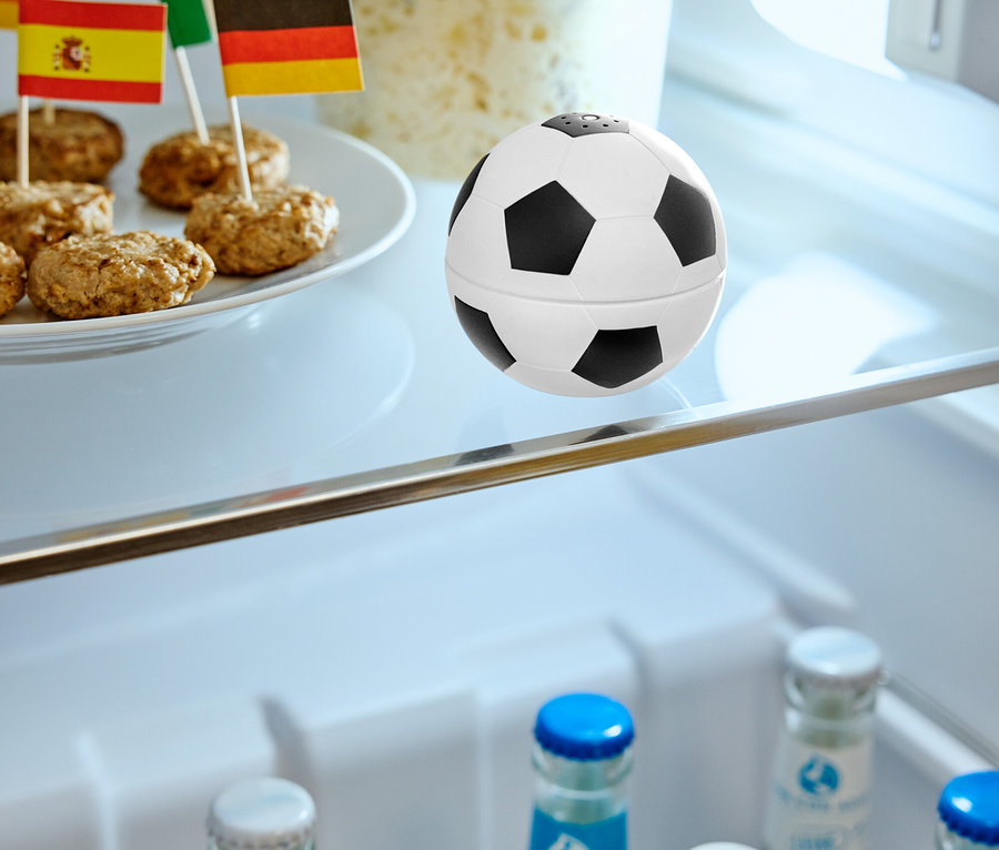 Dans le réfrigérateur se trouvent des boulettes de viande avec des drapeaux sur une assiette, une boîte de nourriture et un ballon de football.