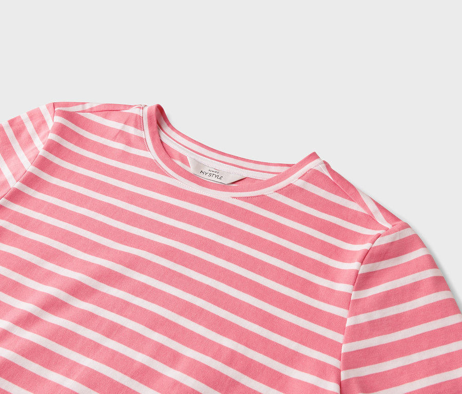 Gros plan d'un t-shirt à rayures horizontales roses et blanches.
