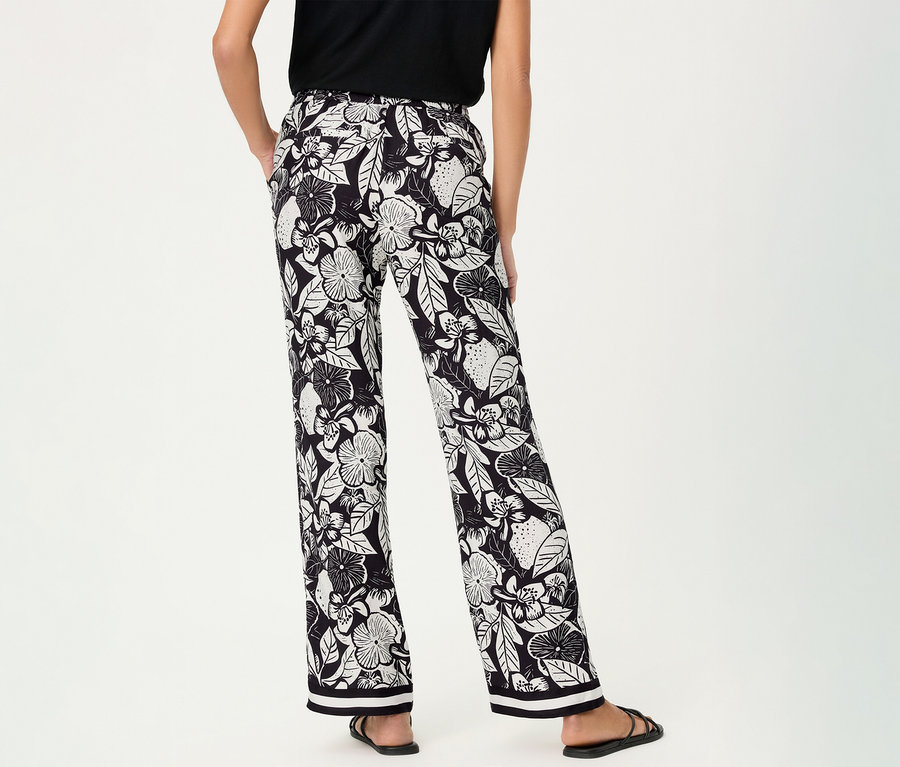 Femme de dos portant un pantalon large Olsen à motif floral et des sandales noires.