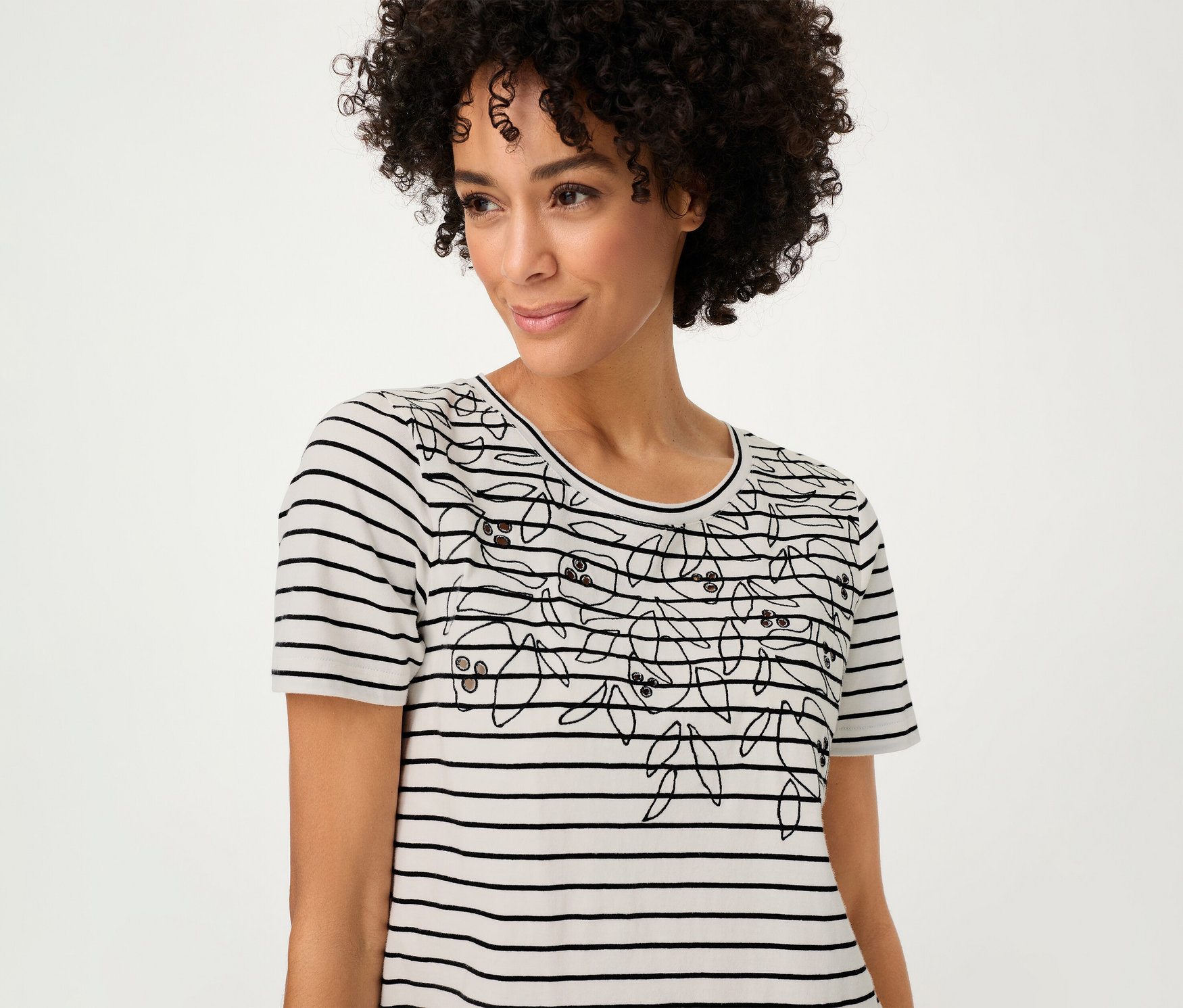 Femme portant un T-shirt Olsen rayé avec un motif floral.