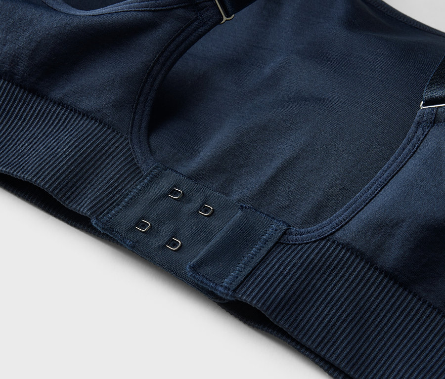 Gros plan d'un soutien-gorge bleu marine avec fermeture à agrafes et bretelles réglables.
