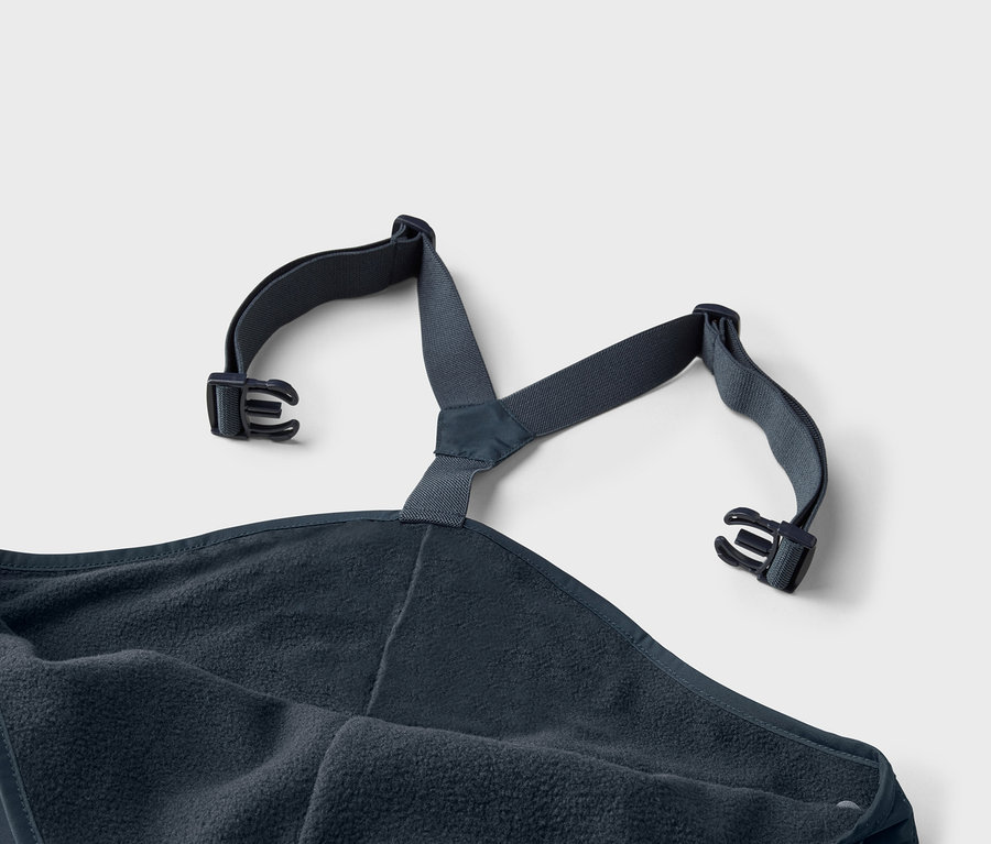 Gros plan d'un poncho de bain bleu marine avec intérieur en polaire et bretelles réglables avec boucles.