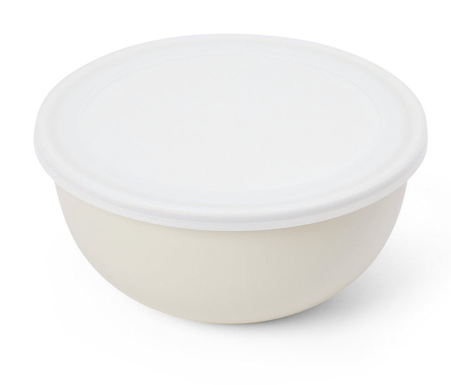 Un bol crème avec un couvercle blanc repose sur une surface blanche.