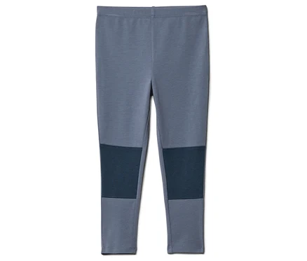 Un legging gris avec des pièces aux genoux bleu marine, posé sur un fond blanc.
