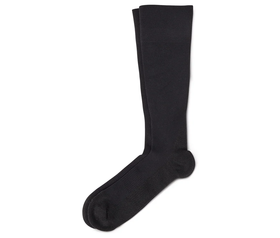Une paire de chaussettes noires montantes sur fond blanc.
