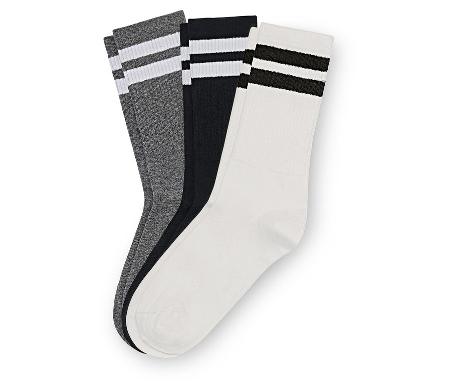 Trois paires de chaussettes grises, noires et blanches sont superposées. Chaque paire a deux rayures en haut.