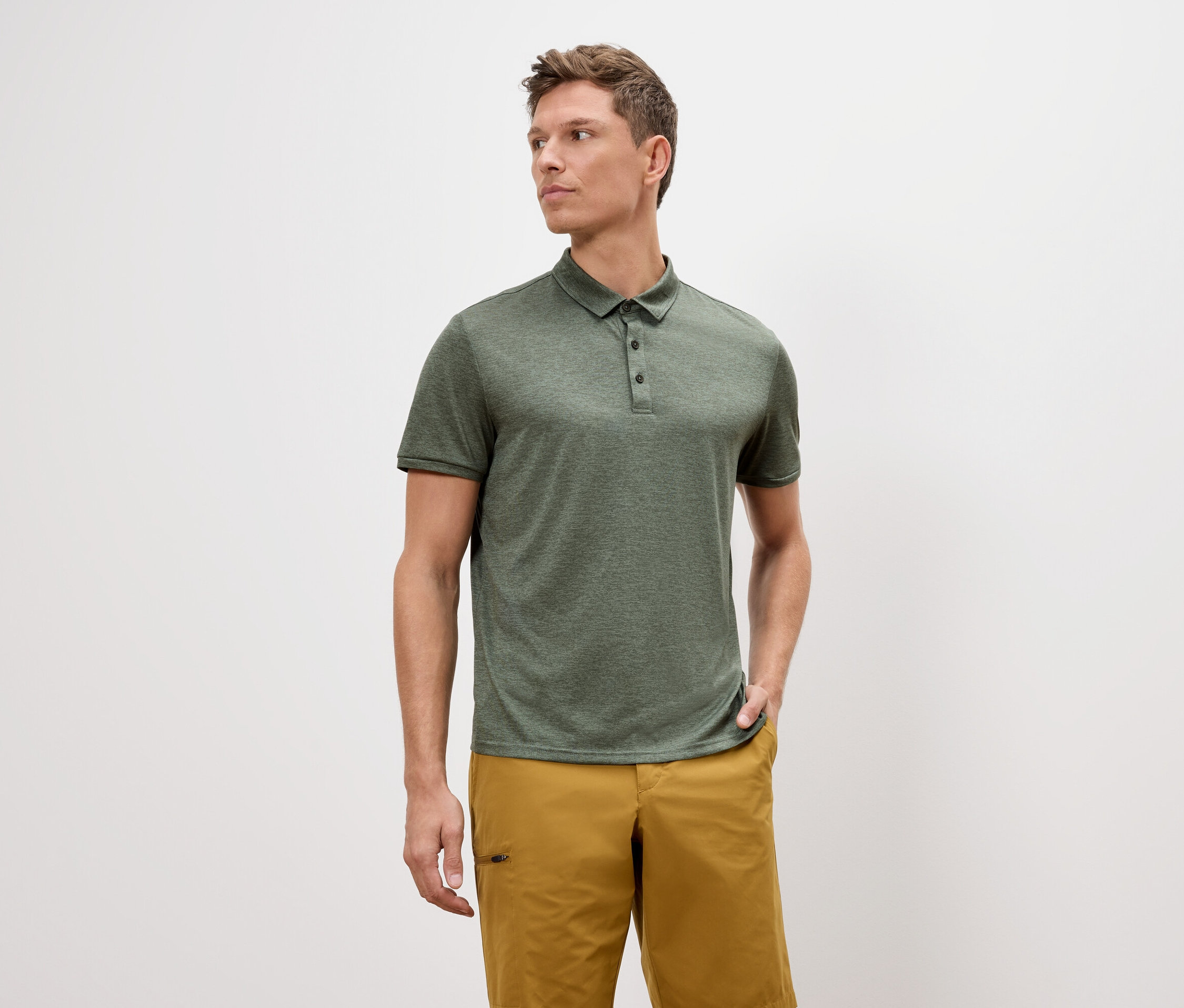 Homme portant un polo vert et un short doré.