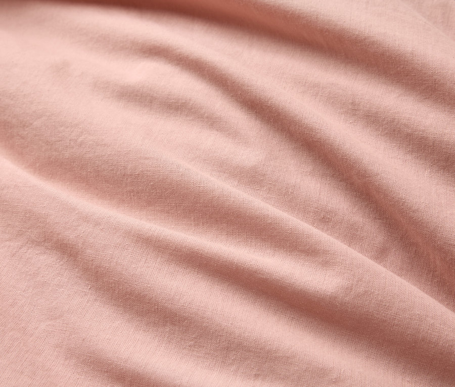 Gros plan d'un tissu rose clair ondulé.