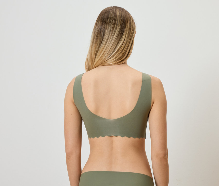 Vue arrière d'une femme blonde portant un soutien-gorge vert et des sous-vêtements assortis.