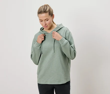 Femme tenant le cordon d'un sweat à capuche vert menthe.