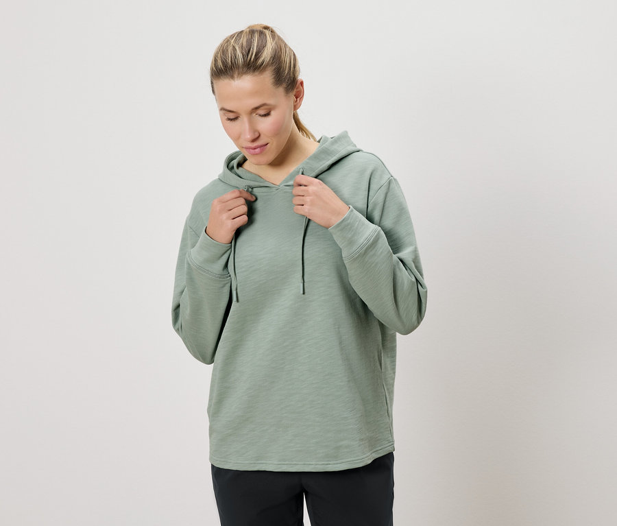 Femme tenant le cordon d'un sweat à capuche vert menthe.