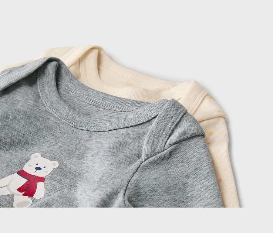 Deux bodys pour bébé, un gris avec un imprimé ours polaire et un crème à étoiles, sont superposés.