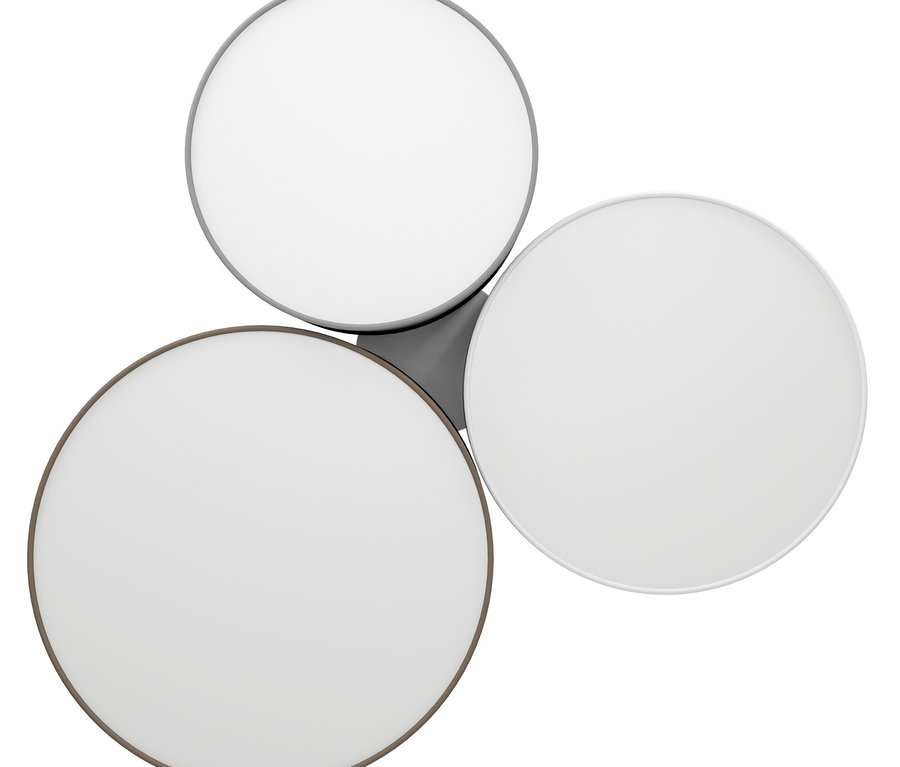 Plafonnier composé de trois éléments lumineux ronds. Chaque élément possède un diffuseur blanc et un bord métallique de couleur différente : gris foncé, gris clair et blanc. Les éléments sont disposés en triangle et connectés par une base grise.