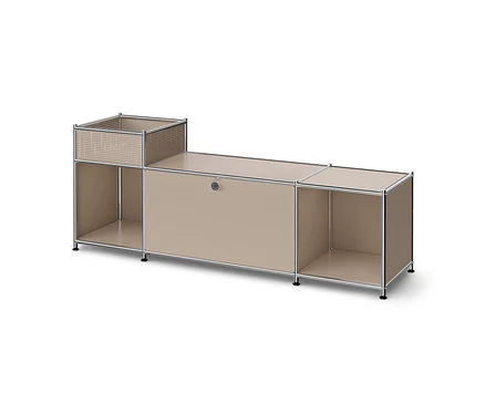 Un buffet modulaire beige avec un cadre chromé, composé d'une étagère ouverte et d'un panier perforé à gauche, d'un compartiment fermé avec poignée et d'une étagère ouverte au centre, et d'une autre étagère ouverte à droite.