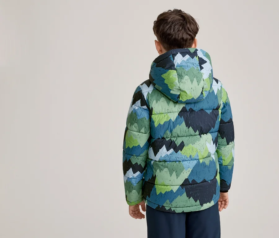 Un jeune garçon vu de dos, portant une doudoune à capuche avec un motif de montagnes vertes et bleues. Il porte également un pantalon foncé.