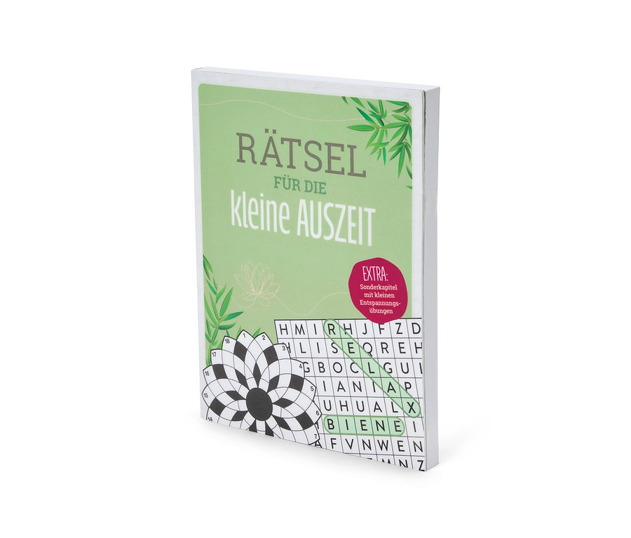 Un livre de puzzles intitulé "Rätsel für die kleine Auszeit" est posé sur une table. Le livre a une couverture verte avec des inscriptions blanches et une image de feuilles de bambou.