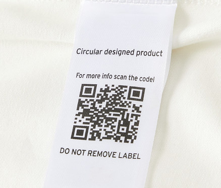 Gros plan sur un des 5 bodys évolutifs pour bébé avec un code QR sur l'étiquette.