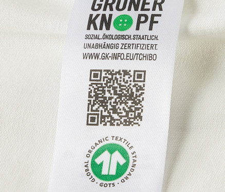 Gros plan sur l'étiquette avec le logo et la certification de coton biologique sur 5 bodys évolutifs pour bébé.