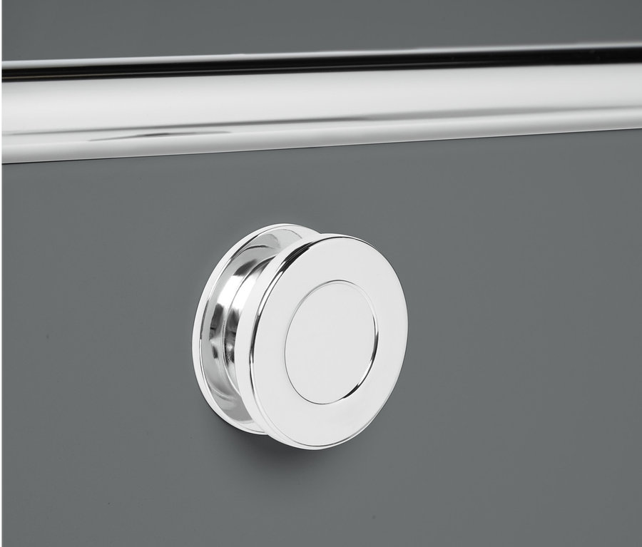 Gros plan sur un meuble bas en métal « CN3 » gris avec des abattants et une poignée ronde argentée.