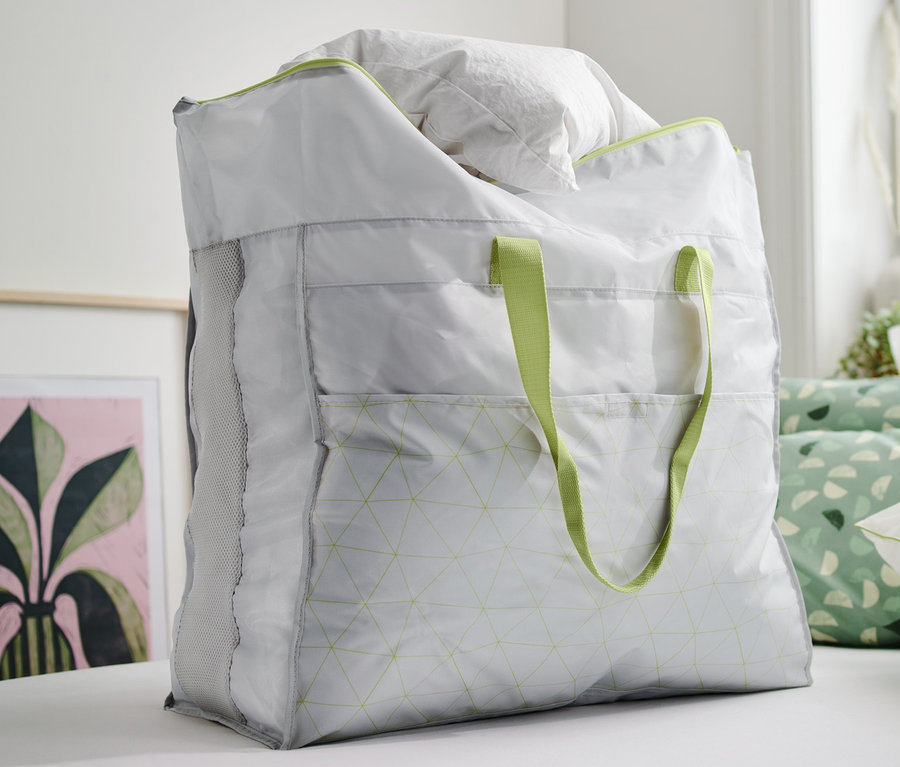 Un sac à literie jumbo rempli de linge de lit blanc posé sur un lit.