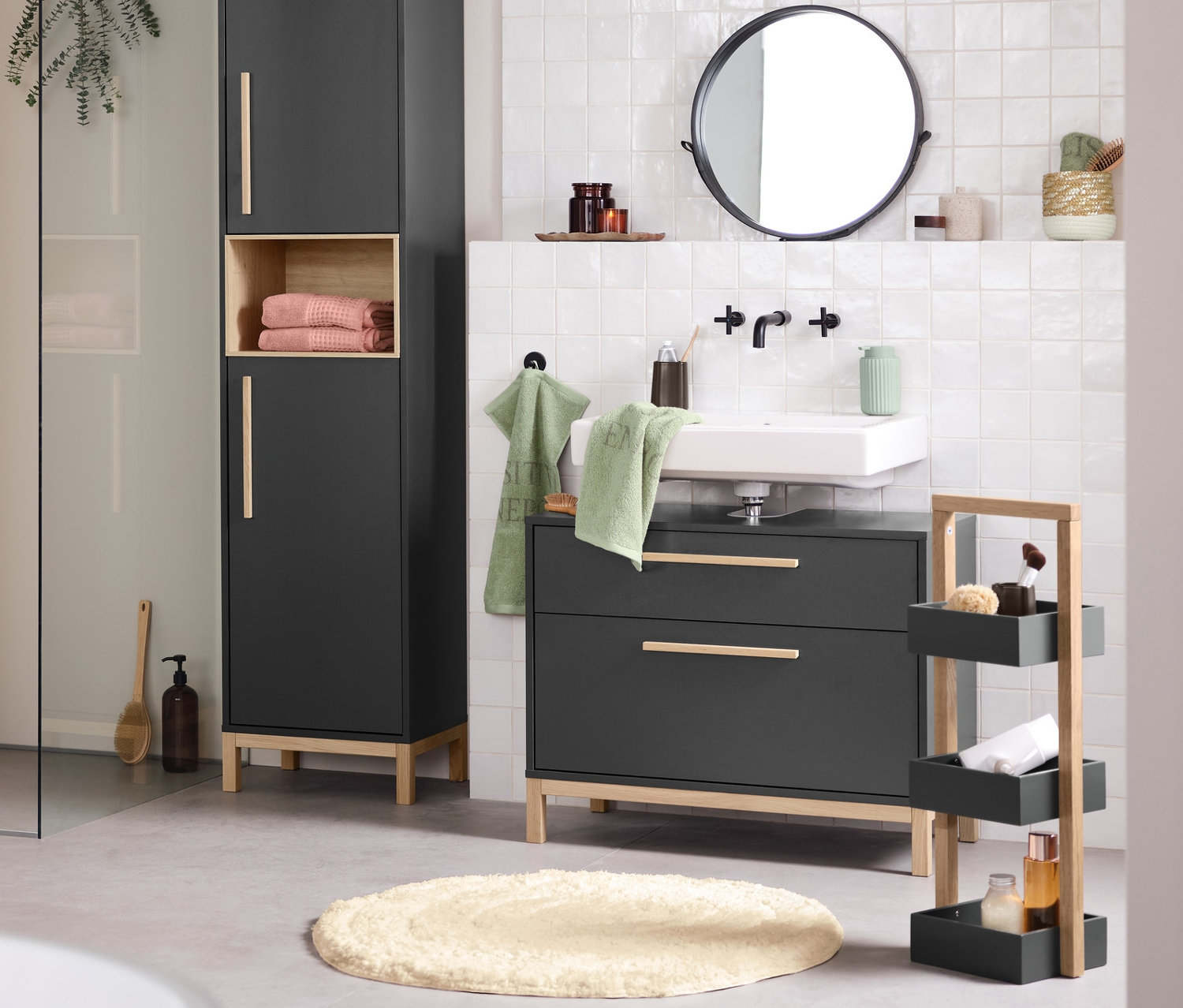 Intérieur de salle de bain avec lavabo, miroir et meubles de salle de bain Eklund anthracite. Une baignoire est au premier plan.