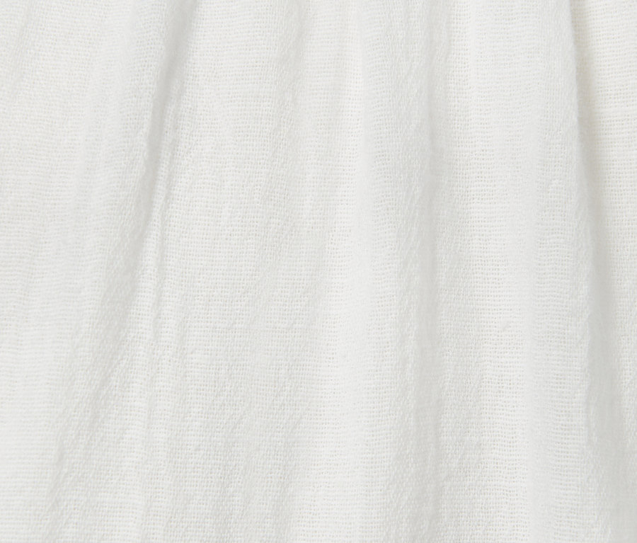 Gros plan d'une blouse blanche avec effet froissé.