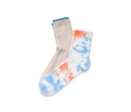 Deux paires de chaussettes : une paire beige avec une bordure bleue et une paire blanche avec un motif tie and dye orange et bleu.
