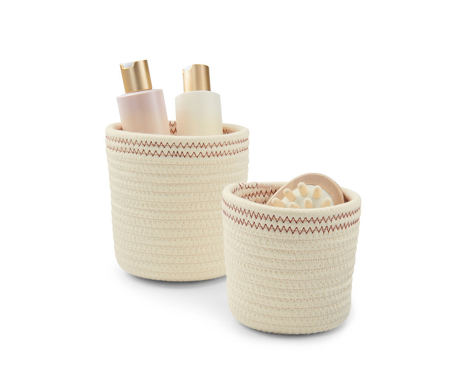 Deux corbeilles de rangement blanc crème-rouille, dont une avec deux bouteilles.