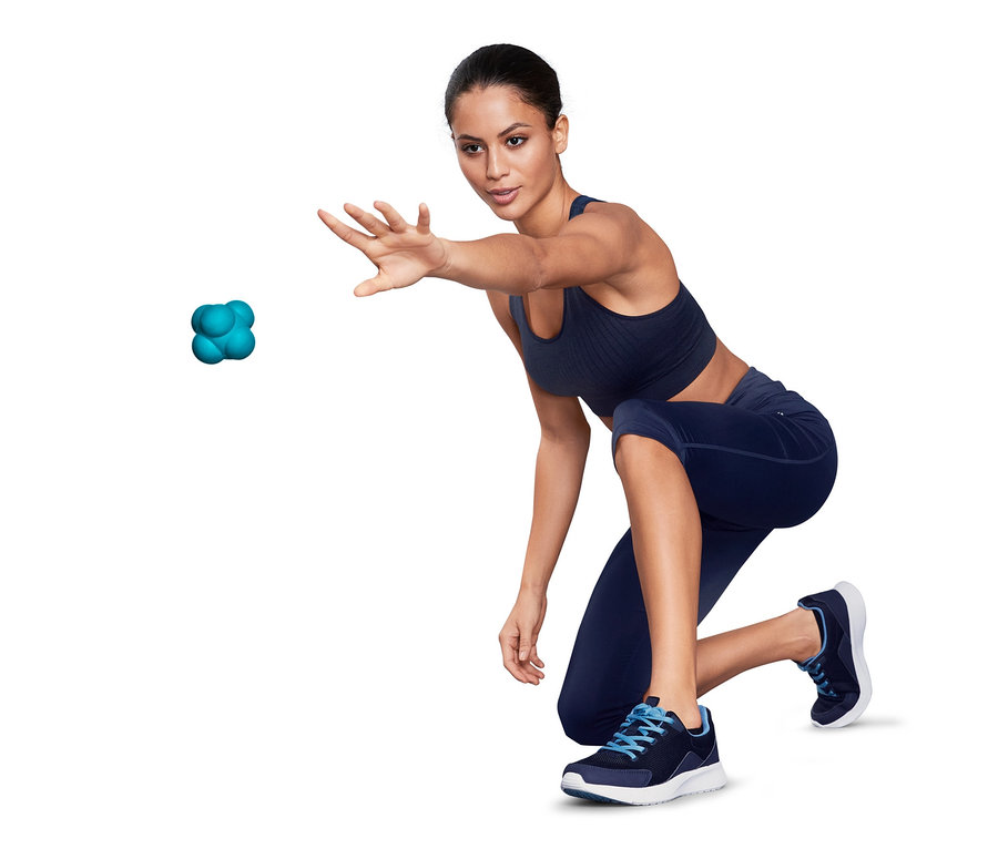 Femme en tenue de sport lançant une balle de massage et de réactivité turquoise.
