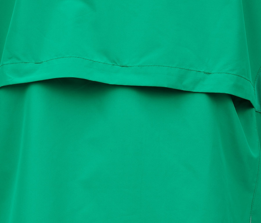 Détail d'une veste fonctionnelle coupe-vent verte.