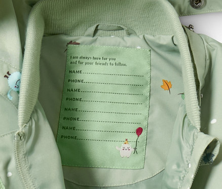 Intérieur d'une combinaison de pluie verte avec un espace pour le nom et le numéro de téléphone.