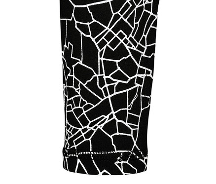 Gros plan sur un t-shirt technique à manches longues noir et argenté avec un motif géométrique.