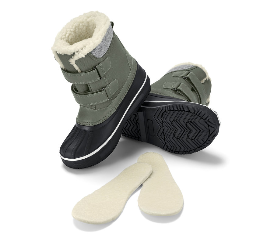 Bottes polyvalentes vertes pour enfant avec semelles intérieures, une botte debout, l'autre sur le côté.